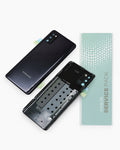 A Samsung smartphone service pack kit on a white background, showing a black Samsung phone back cover, a matching phone back cover without the rear panel, and a mint green 'mobile SERVICE PACK' card.