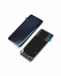 A Samsung smartphone shown from the back in two views: one intact dark navy phone and one with a black protective back cover installed, both on a clean white background.