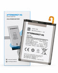 A replacement smartphone battery by AFTERMARKET HQ, shown both inside its retail box and as a loose battery. The battery is primarily white with black text and a small orange connector tab on the right side.