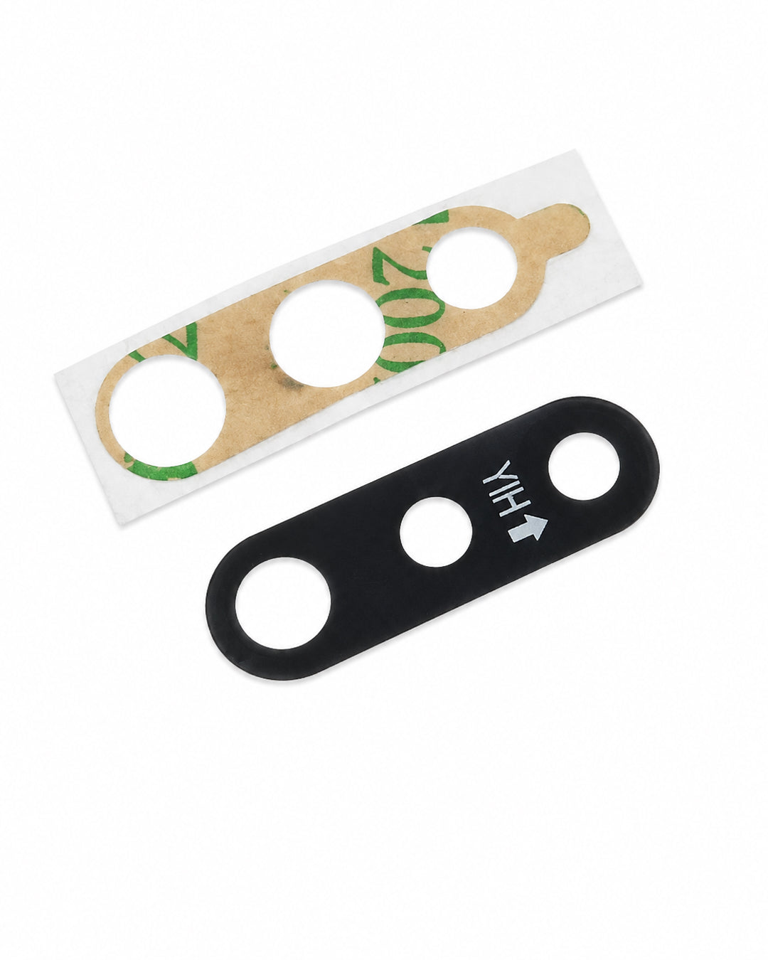 Two replacement lens protectors for a smartphone camera lens: one black silicone protector with white printed alignment markings, and one clear protective film with a brown adhesive backing and green tape remnants, shown on a plain white background.
